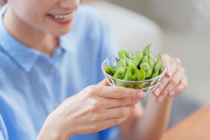おつまみの枝豆を食べる女性