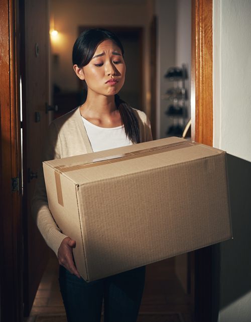 荷物を持って首をかしげる女性