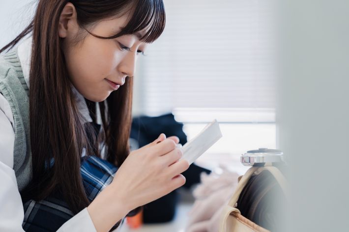 学校でメイクをする女子高生