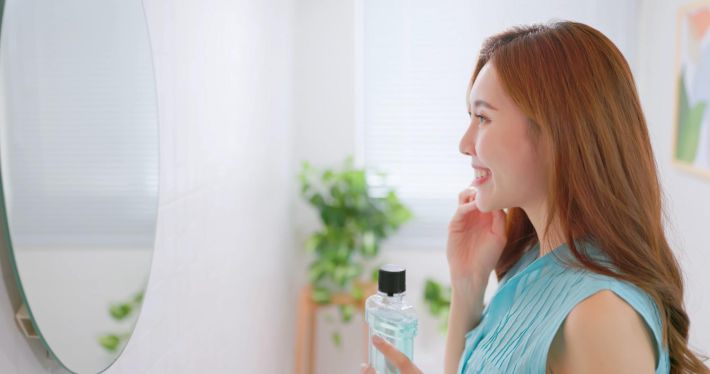 鏡で口の中をチェックする女性