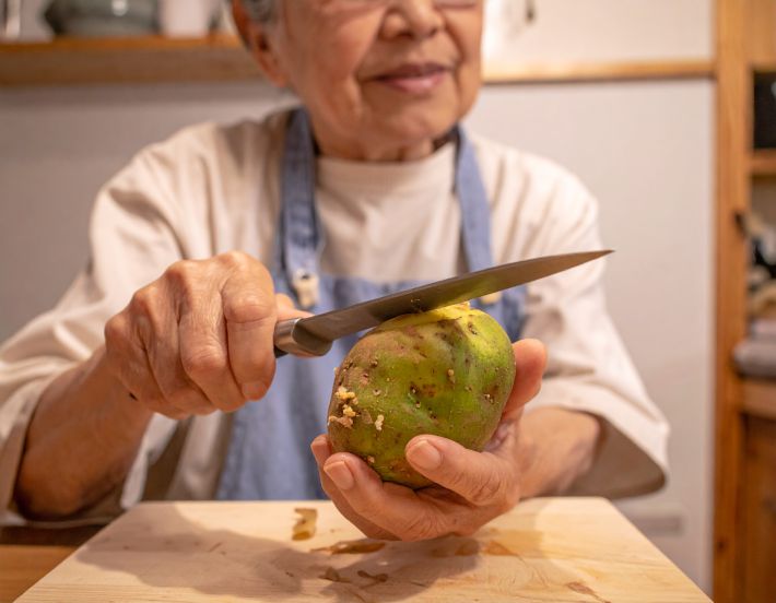 じゃがいもの皮を剥く老婆