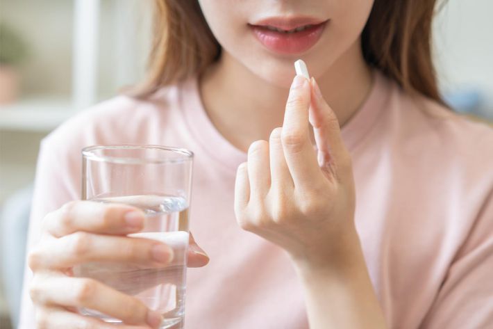 薬を飲む女性