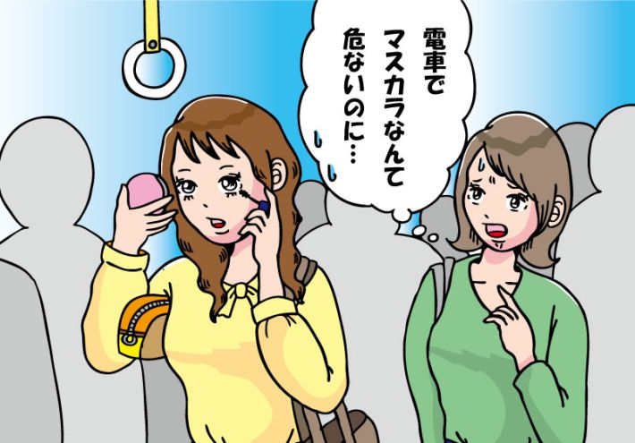 帰宅ラッシュの電車でメイクをする女性