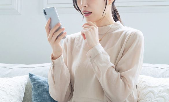スマホを見て驚く女性