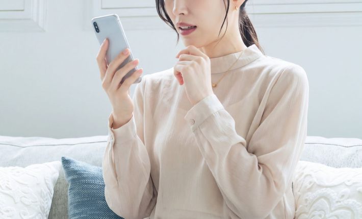 スマホを見て驚く女性